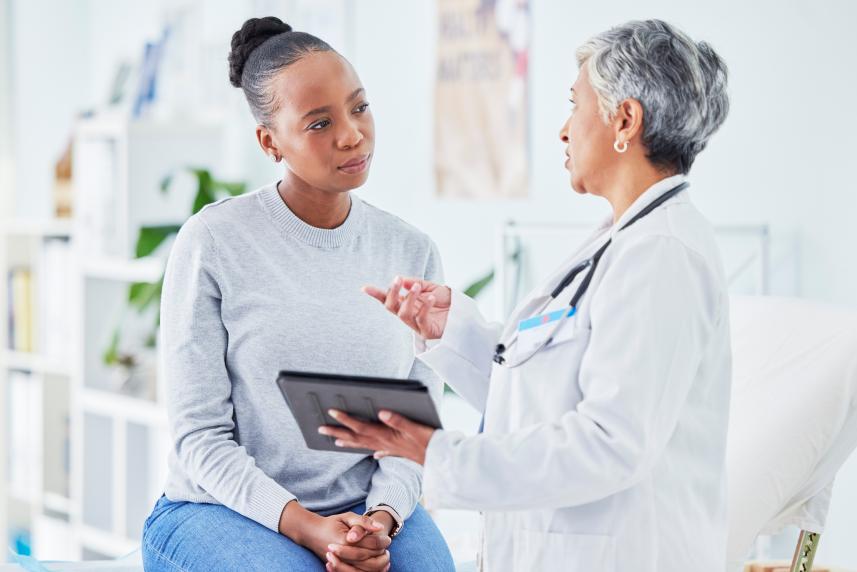 A woman speaks with her doctor during a visit