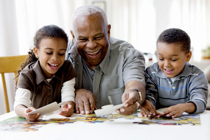 Mature man doing puzzle with grandchildren
