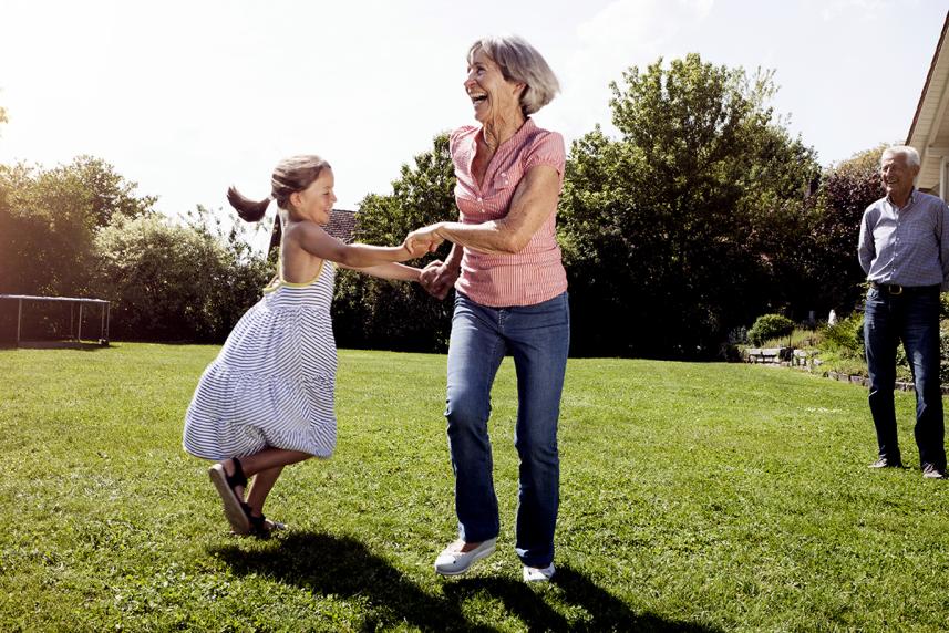 Mature woman playing with young granddaughter outdoors