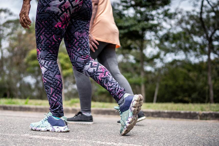 Waist down view of women in sneakers walking outdoors