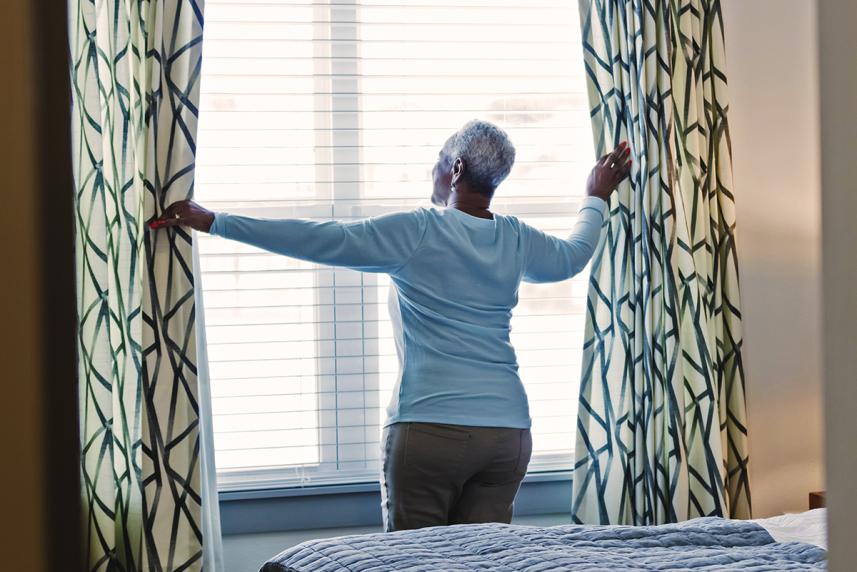 Mature woman opening curtains