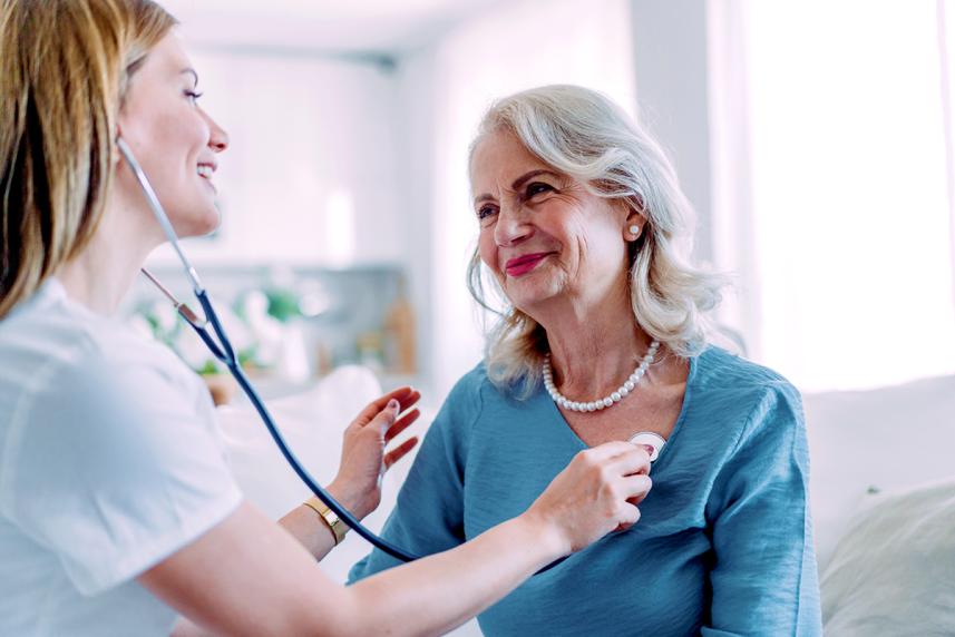 Female doctor listening to mature female patient's heart with stethoscope