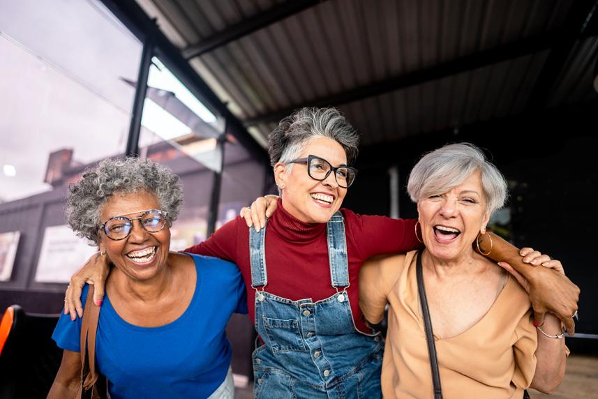 3 mature woman laughing and walking together