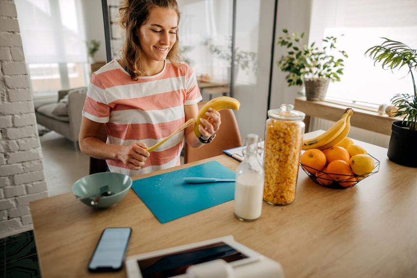 Woman peeling a banana in a kitchen