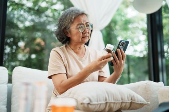 A middle-aged Asian woman reviews her prescriptions