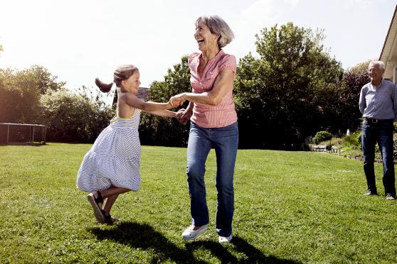 Mature woman playing with young granddaughter outdoors