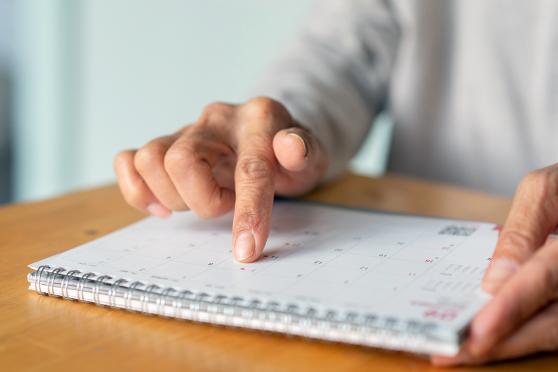 person's hands reviewing calendar