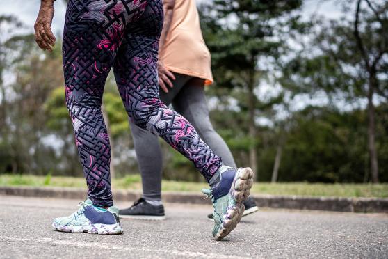 Waist down view of women in sneakers walking outdoors
