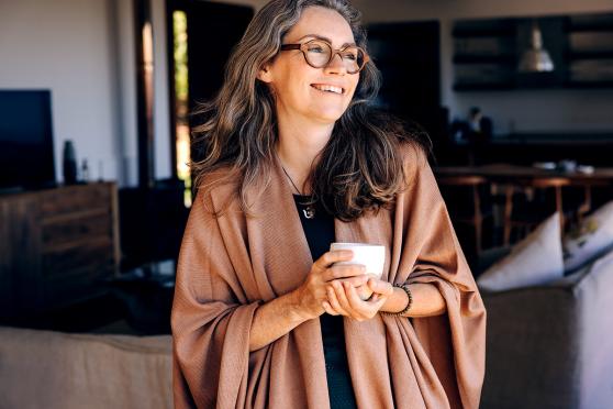 Woman smiling and having a cup of tea indoors