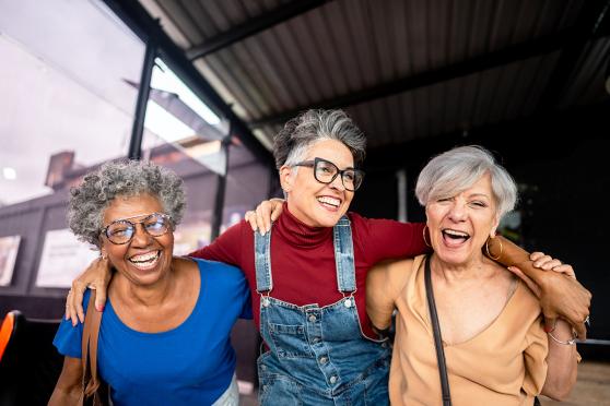 3 mature woman laughing and walking together