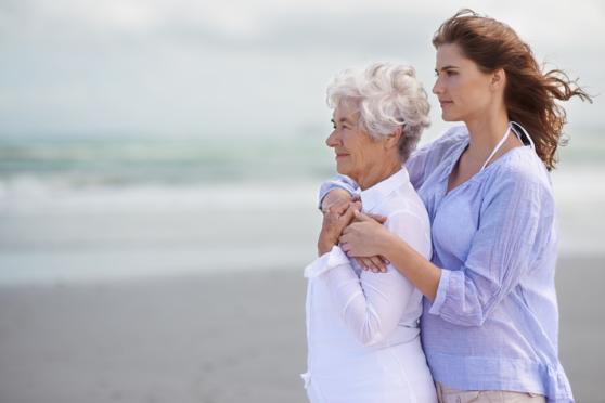Photo: Older woman is being held by daughter on the beach